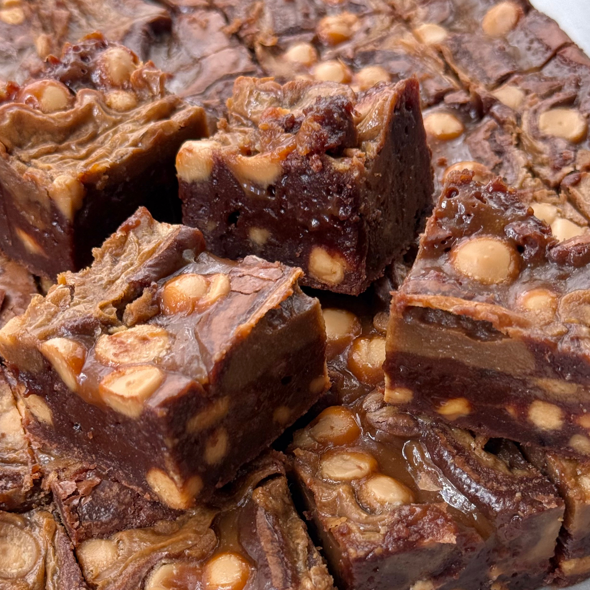 Salted caramel latte brownies piled up, studded with caramel chocolate pieces