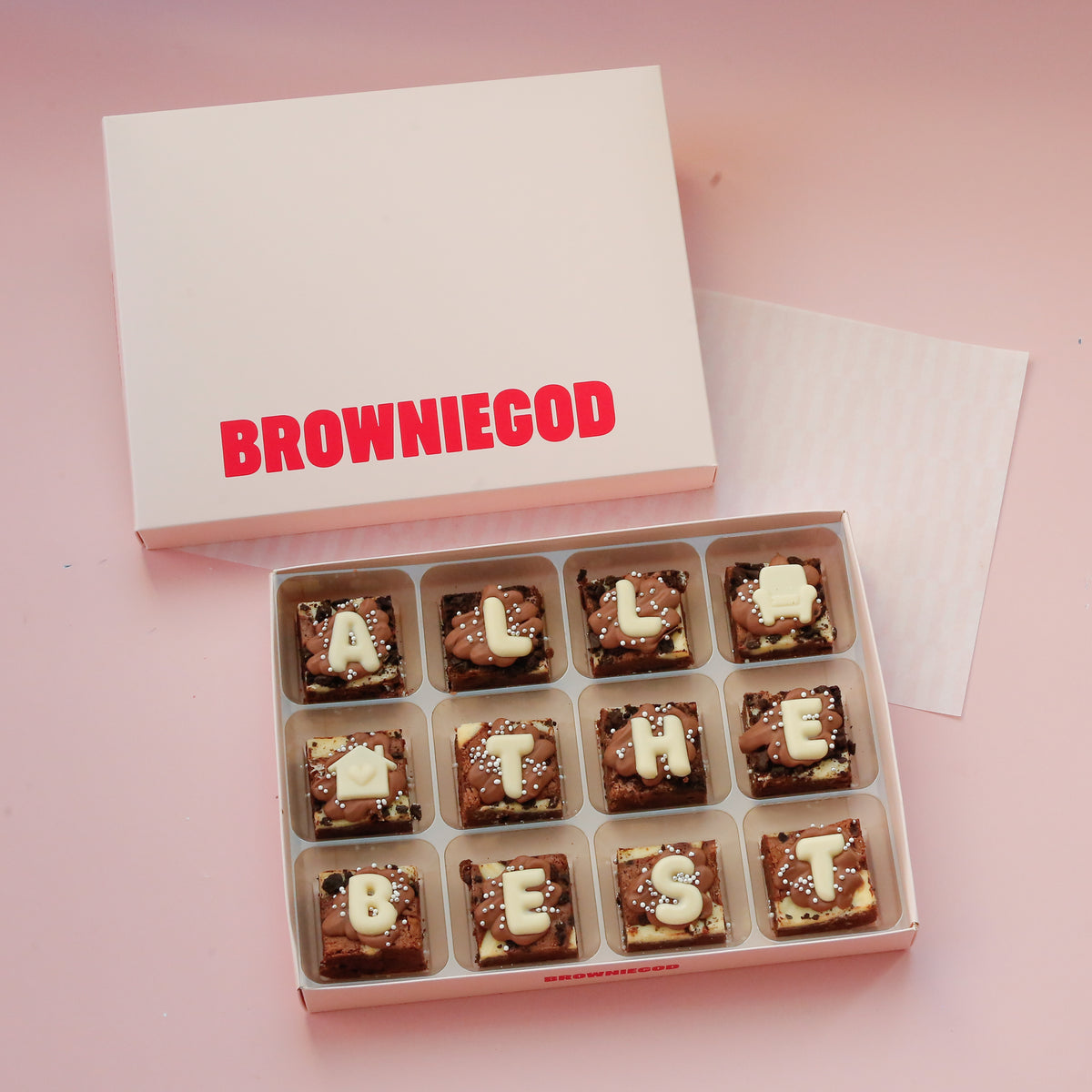 Box of 12 mini brownies spelling "All the best" in white chocolate letters, next to the Browniegod box lid