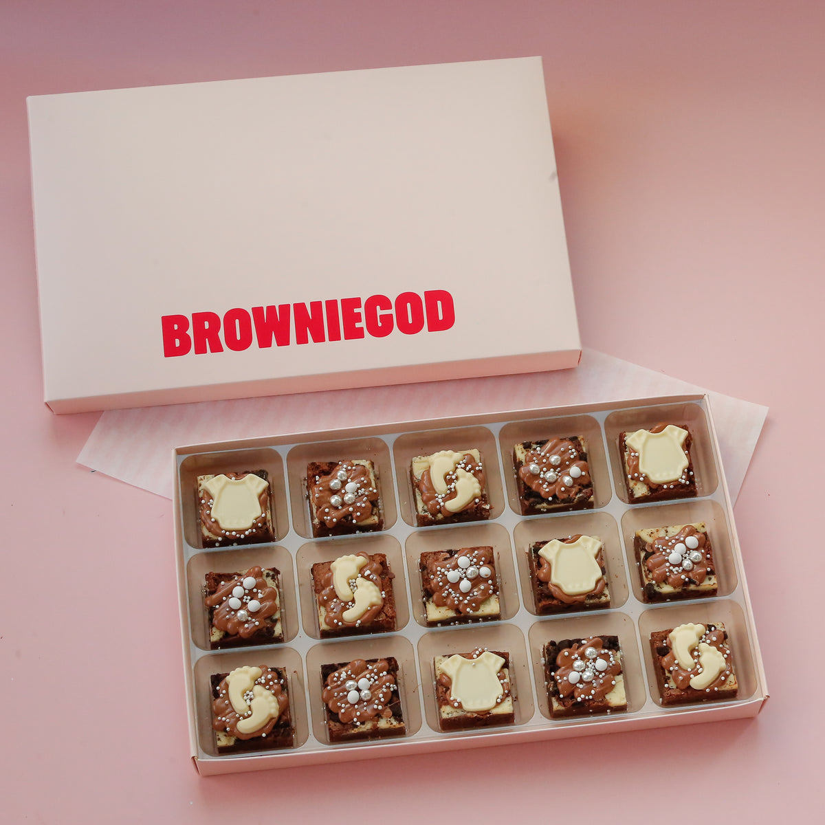 Box of 15 baby mini brownies with white chocolate onesie and letter toppers, next to the Browniegod box lid