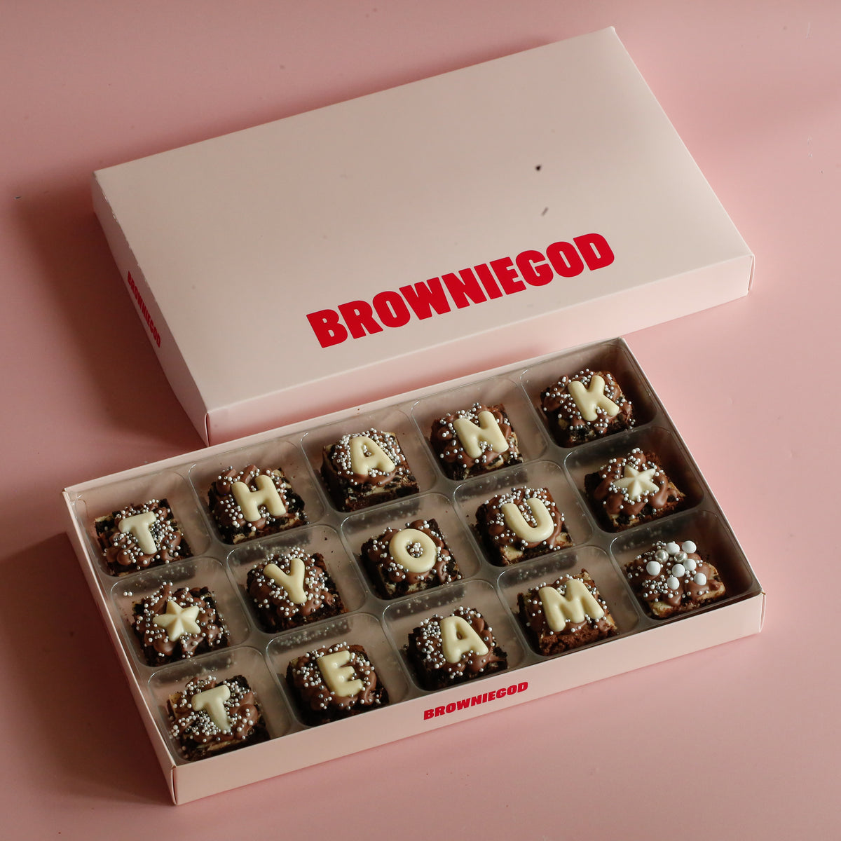 Box of 15 mini brownies spelling "Thank you team" in white chocolate letters, next to the Browniegod box lid