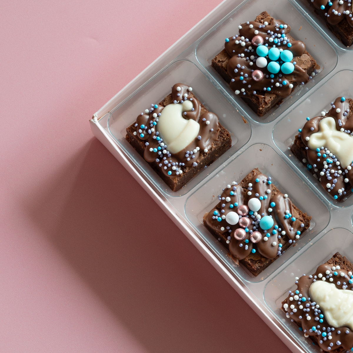 Christmas mini brownies in a tray with white chocolate toppers and blue and pink bauble sprinkles