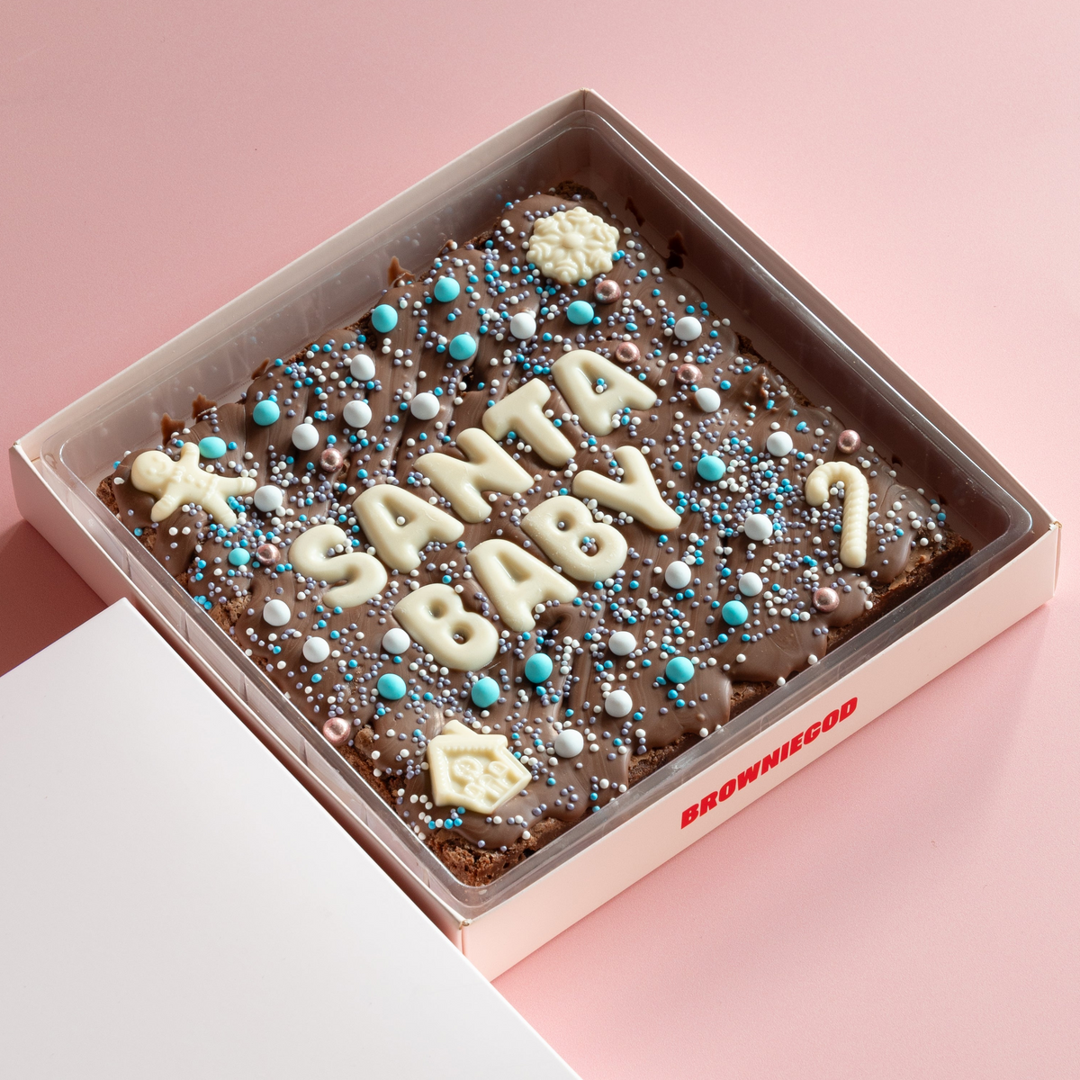 Christmas brownie slab reading "Santa baby" in white chocolate letters with blue, white and silver sprinkles