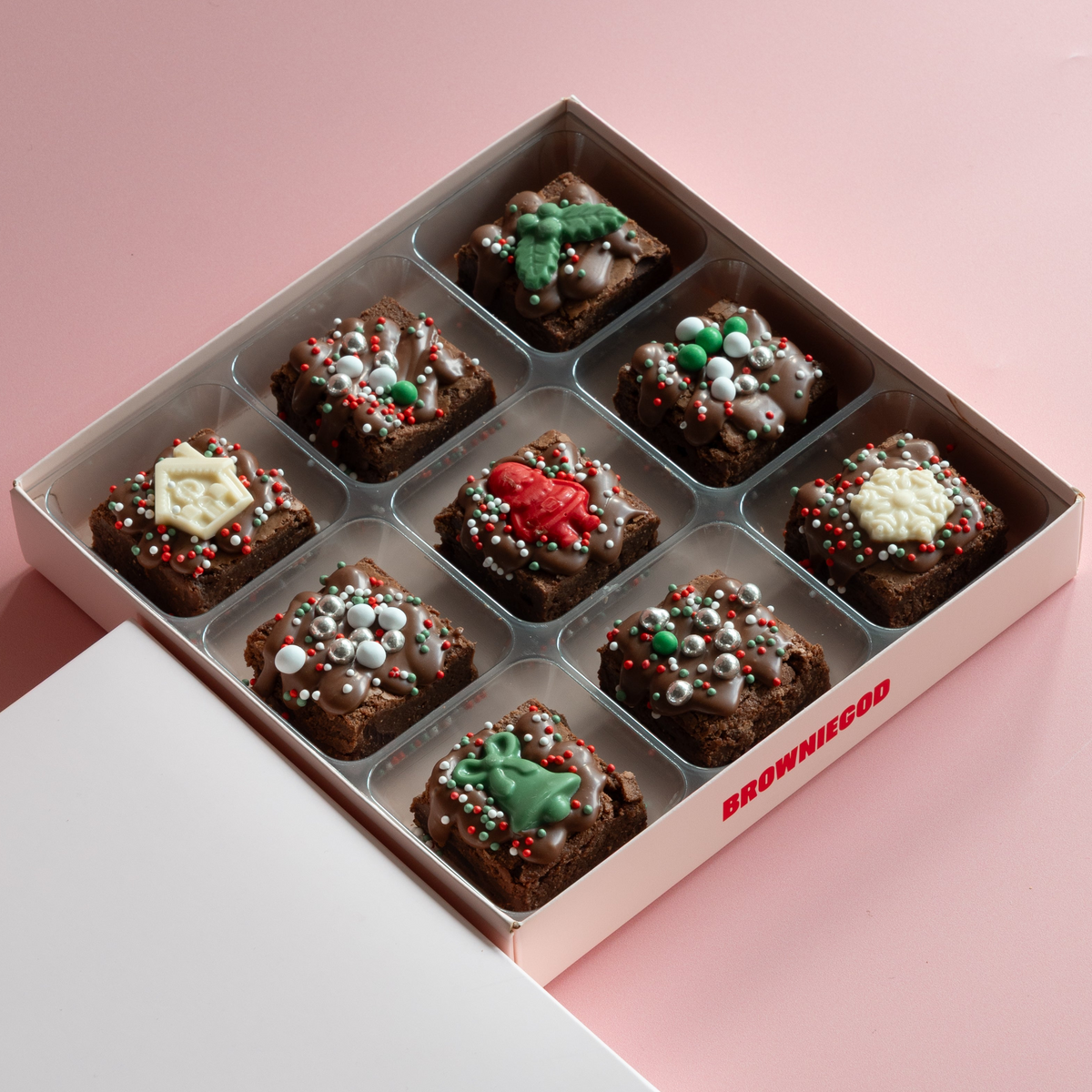 Box of nine Christmas mini brownies with white, red and green chocolate toppers and festive sprinkles