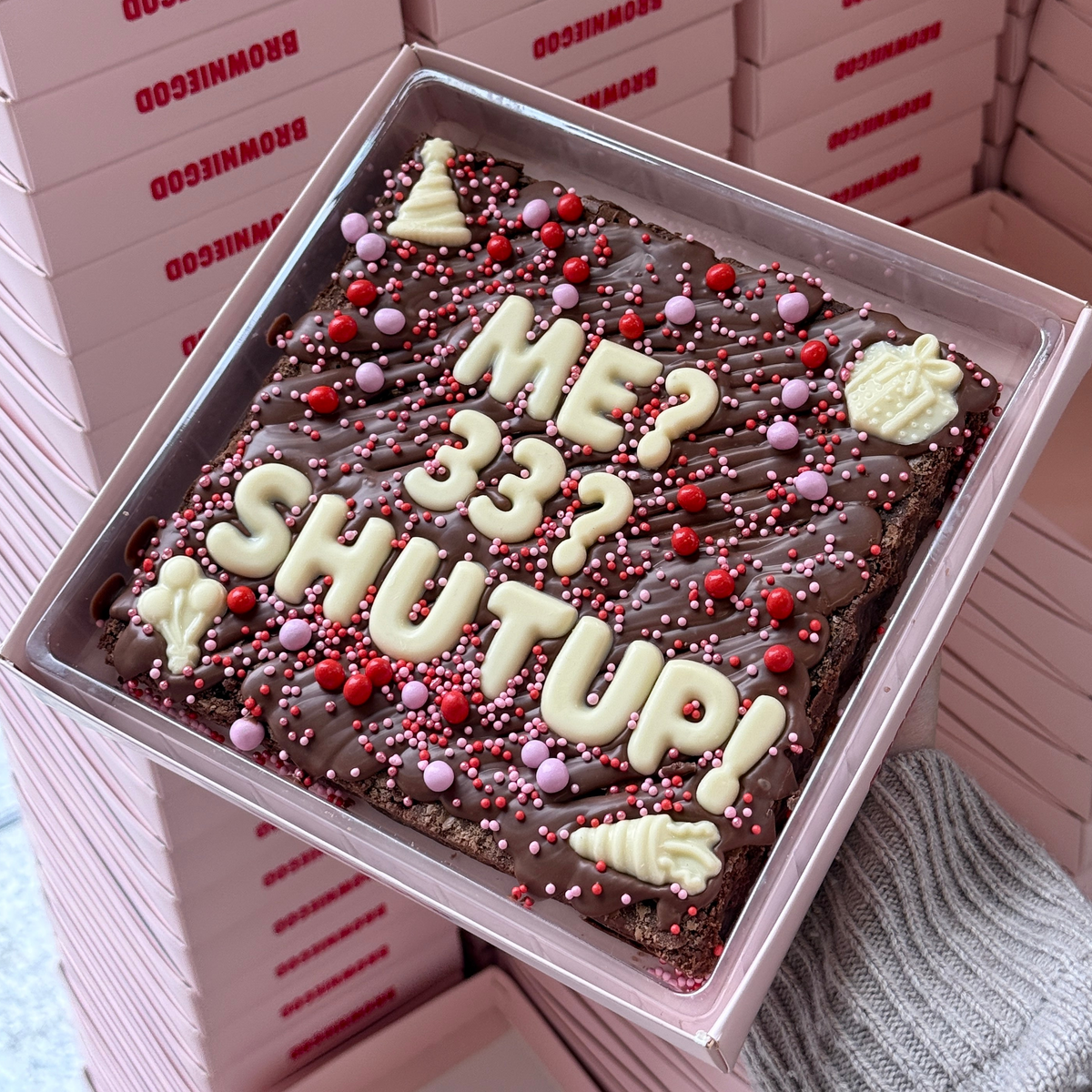 Brownie slab spelling "Me? 33? Shut up!" in white chocolate letters, with pink and red sprinkles and birthday icons