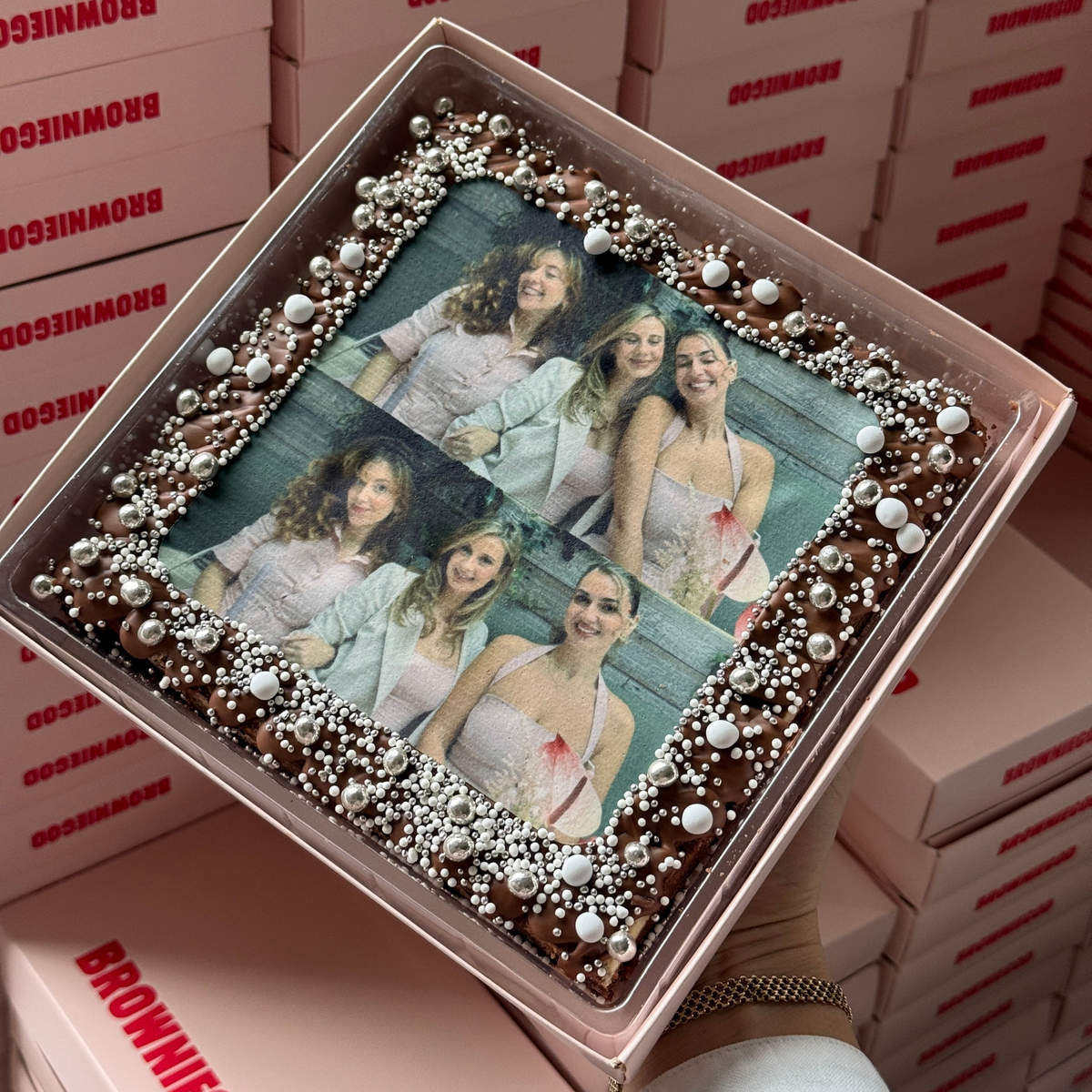 Brownie slab topped with a printed group photo of five people, framed with silver pearl sprinkles